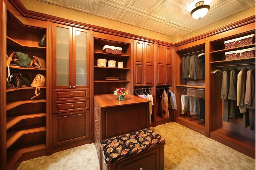 brown wood custom closet system in walk in closet