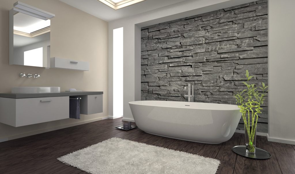 elegant bathroom with stone wall and curved tub