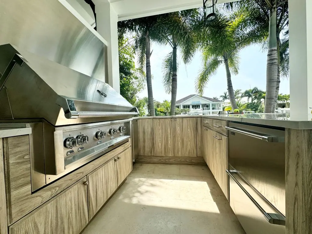 outdoor kitchen with semi-custom cabinetry and palm trees in backgroun